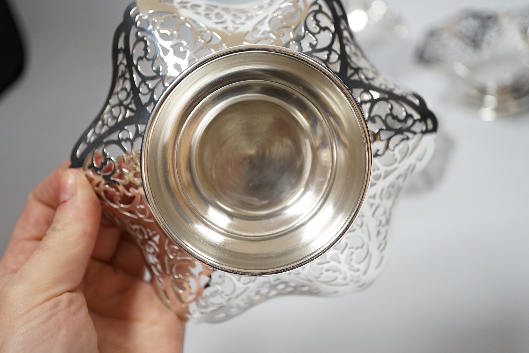 A set of three Elizabeth II pierced silver bonbon dishes, William Bush & Son, Sheffield, 1962, 14.2cm and one other similar silver shallow dish, 16oz.